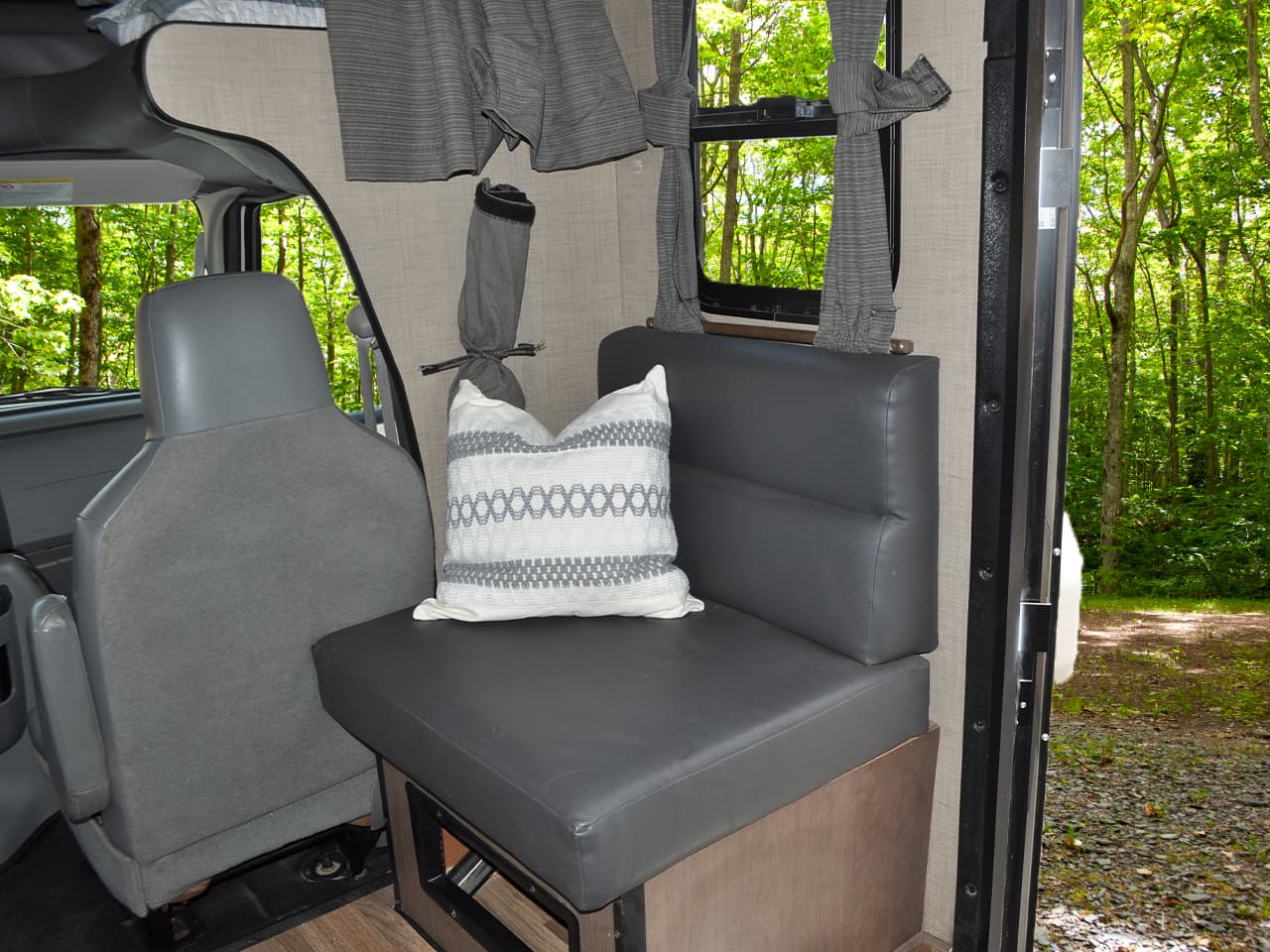 Seating area behind passenger seat with throw pillow