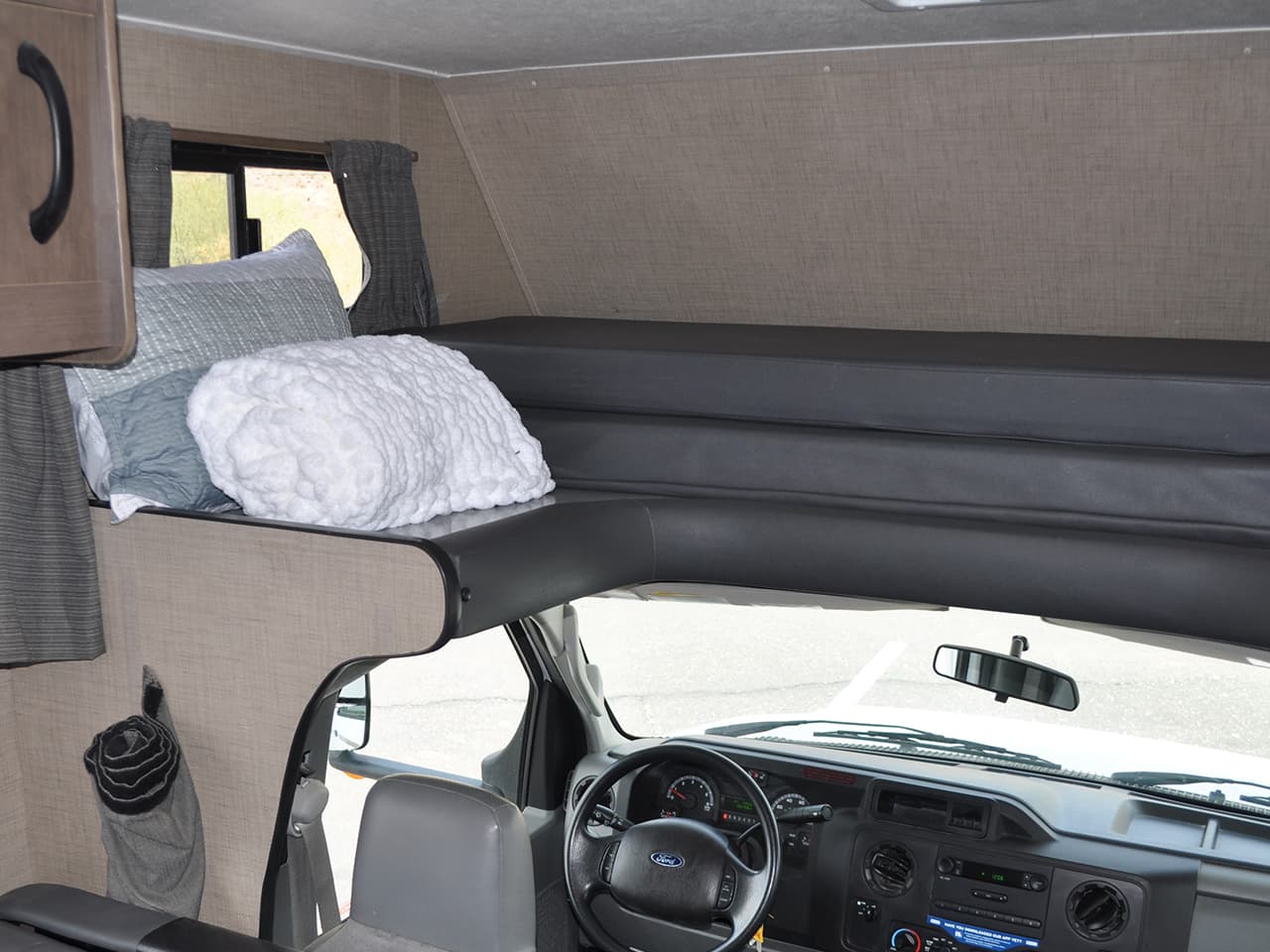Storage area above drivers seat with pillows