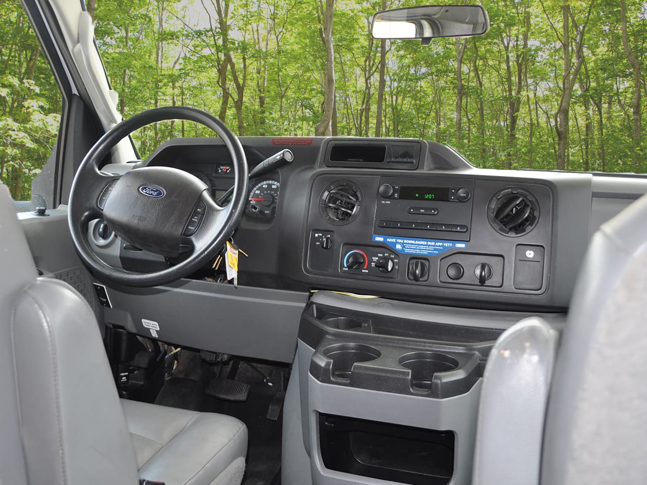 Drivers side dash board showing steering wheel, radio, and environmental controls.