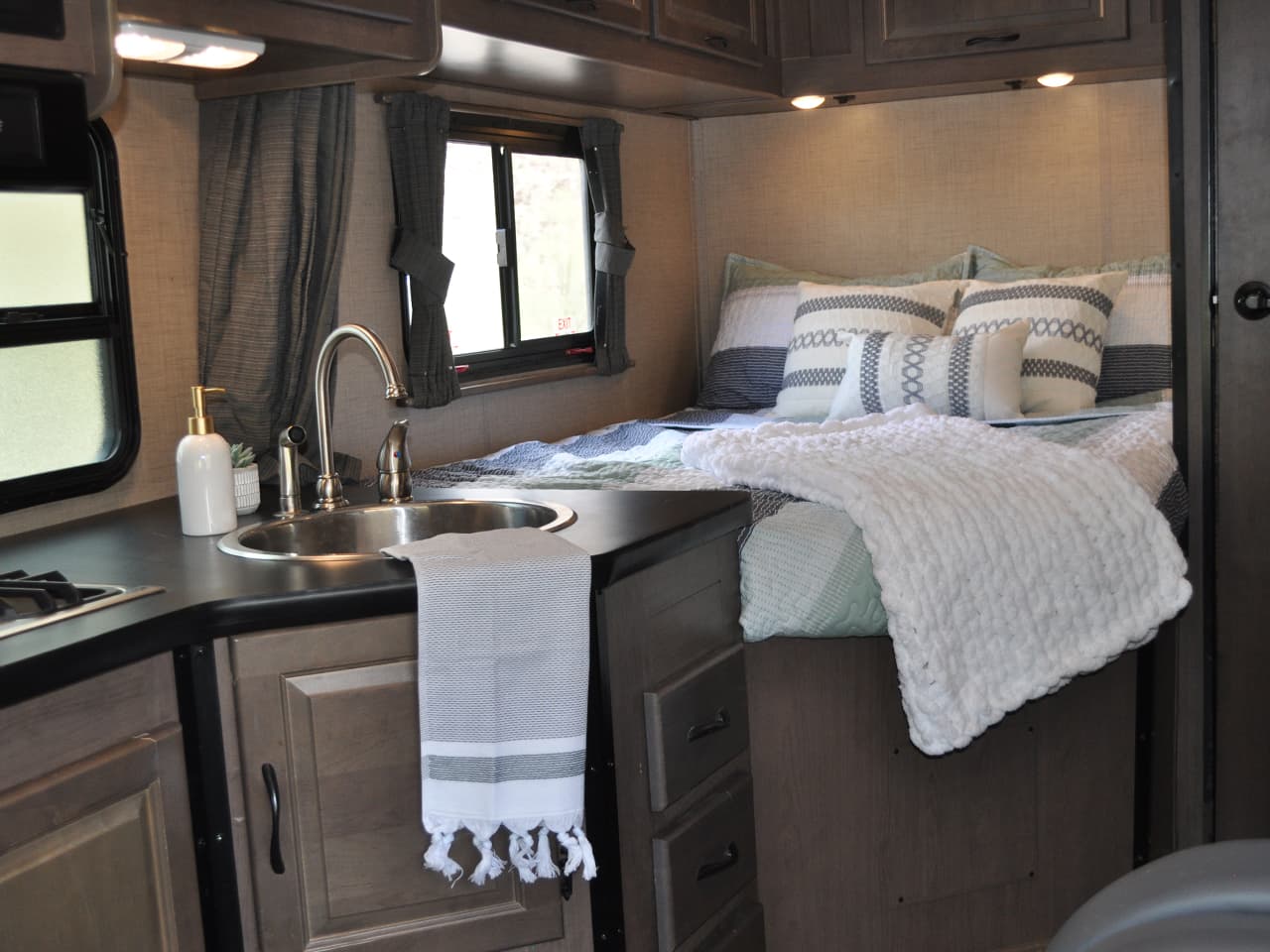 Assembled bed with pillows and quilt, and kitchen sink with towel